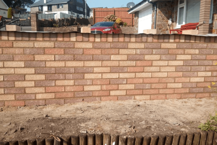 Newly built light red brick front garden wall